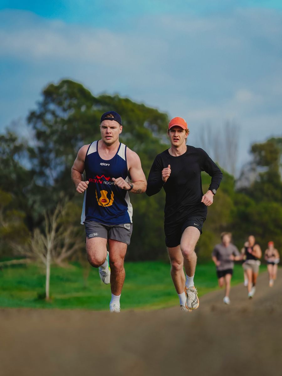 Luke running alongside an athlete during a coaching session